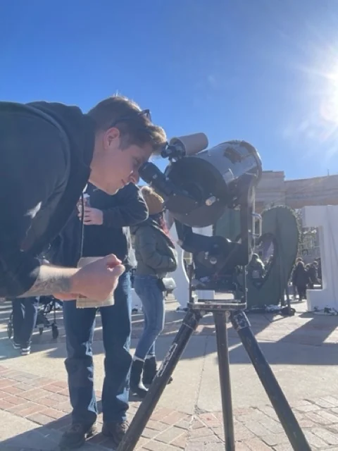 Young visitors and an adult looking through a solar telescope